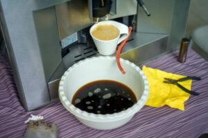 Cleaning bean-to-cup coffee machine placed on a table, indoor shallow DOF closeup