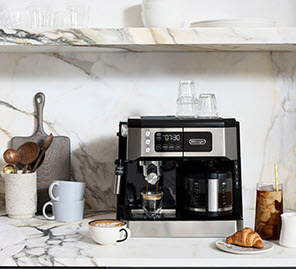 Delonghi Coffee and Espresso Maker sitting in a kitchen with cups and some different coffees