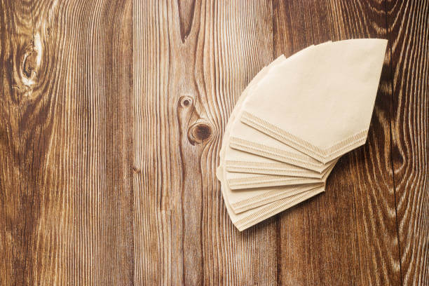 Paper coffee filters on a brown wood background