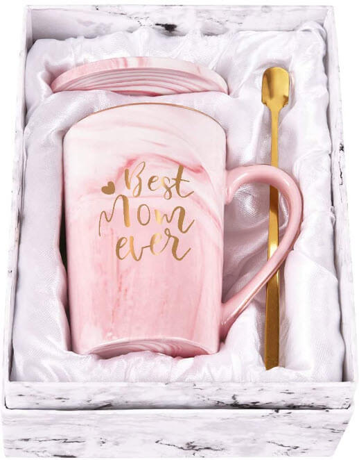 A pink mug with best mom ever written in gold font with a gold spoon packed in a delicate gift box