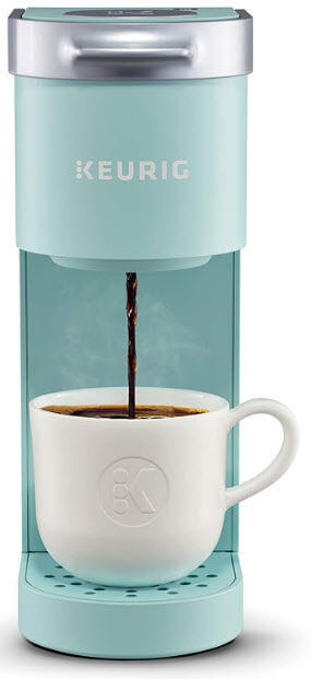 A light blue Keurig coffee maker pouring coffee into a white cup