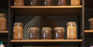 Different roast coffee in glass jars on wooden shelf