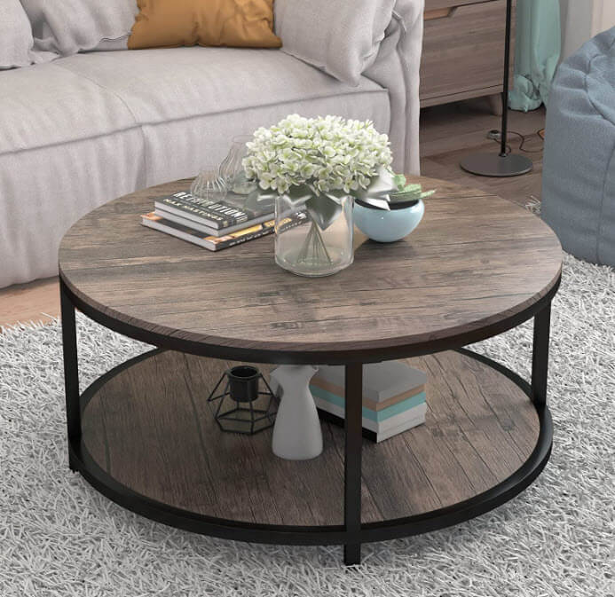 Round wooden coffee table with books and flowers on top