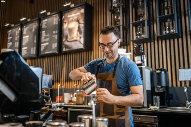 A barista pouring brewed coffee surrounded by the best coffee accessories