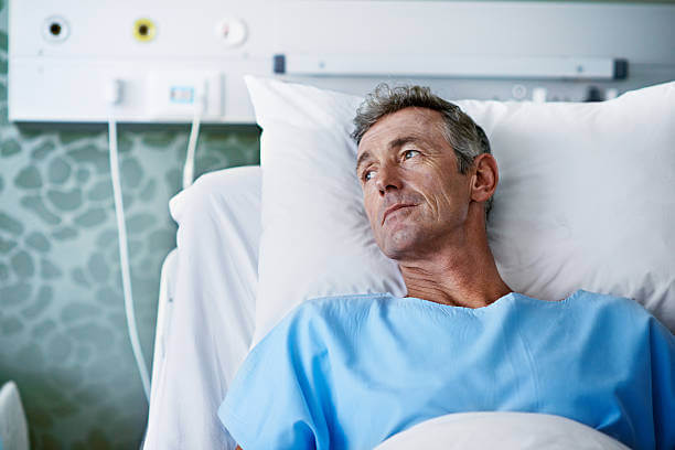 A middle age man laying in a hospital bed from a suspected caffeine overdose, just one of the instant coffee health risks