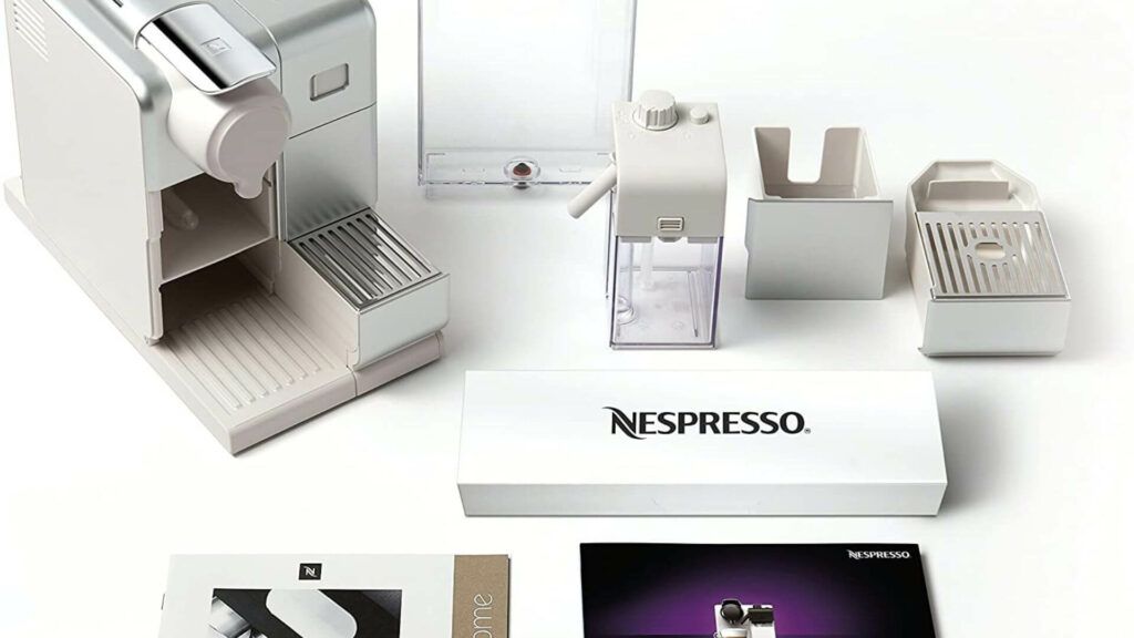 A white Nespresso coffee pod machine with different parts spread around the machine.