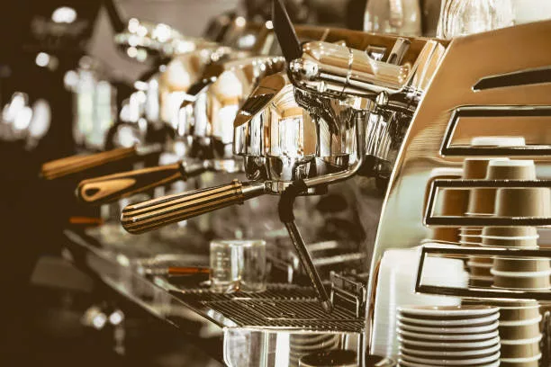 A close up of a shining golden colored Coffee Espresso machine.
