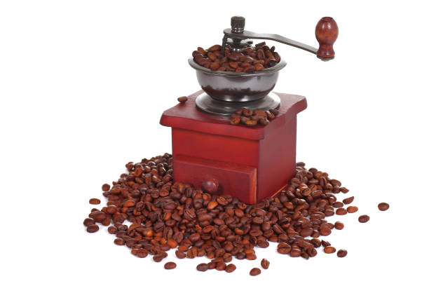 Manual coffee grinder in a heap of a coffee beans