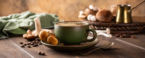 Banner with mushroom coffee in green cup on wooden background. New Superfood trendy healthy concept with copy space, selective focus.